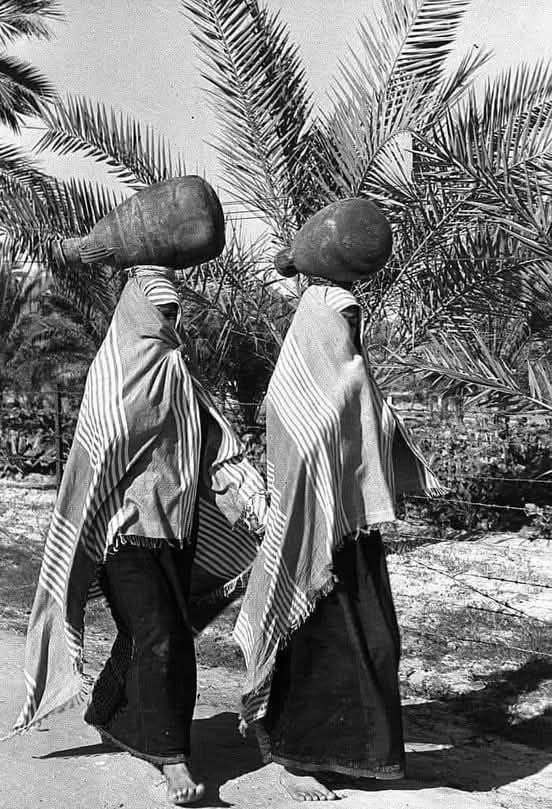 صورة قديمة لسيدتان من دير البلح وسط قطاع غزة في طريقهن لتعبئة جرار المياه من أحد الآبار سنة 1956