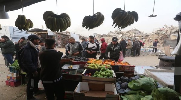 مواطنون يتسوقون في سوق أقيم بين الأنقاض في مخيم جباليا شمال غزة، خلال شهر رمضان المبارك 2025، نقلاً عن : شبكة وفا الإخبارية